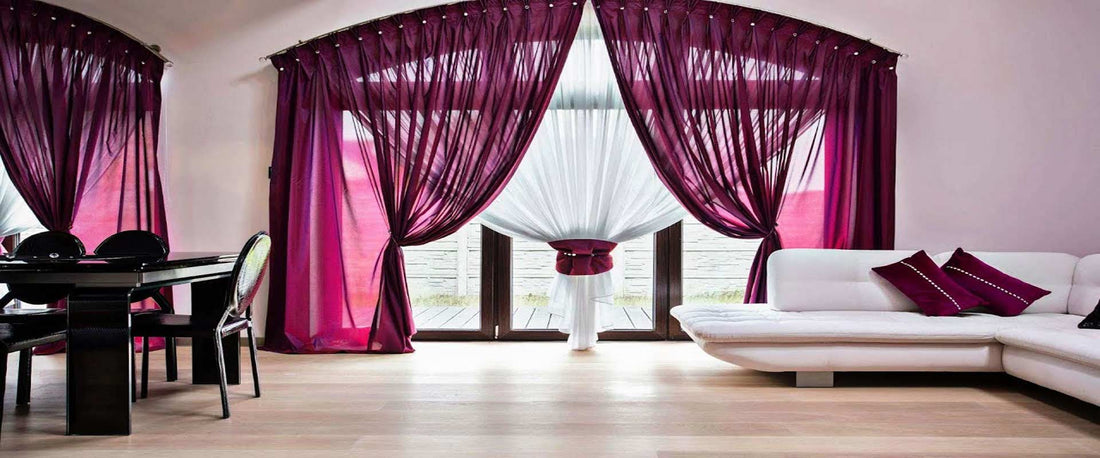 Moderne leefruimte met grote glazen schuifdeur, magenta gordijnen, witte L-bank en zwarte eettafel. Eigentijdse inrichting, ideaal voor kunstwerken van degrootmeesters.com.