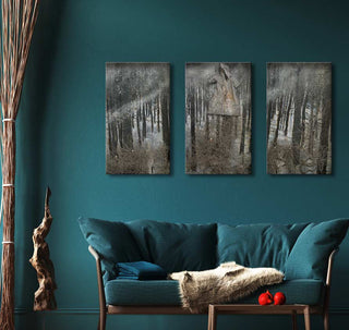 Triptych artwork Anselm Kiefer - Karfunkel Wald depicting a misty forest scene above a teal sofa in a moody, nature-inspired living room setup.