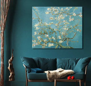Vincent van Gogh - Amandelbloesem schilderij boven een teal bank in een modern ingerichte woonkamer, met houten tafeltje en rode appels.