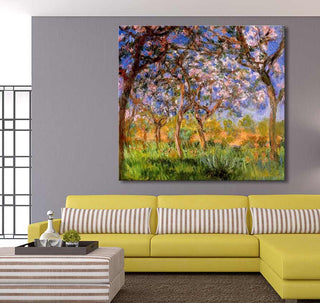 Mustardgele bankhoek met Claude Monet's Olijfbloesem op doek, impressionistisch geschilderd. Boven de bank, schilderij van bloeiende olijfbomen.