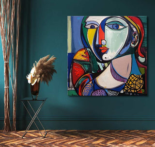 Cubist-style painting Picasso signature - Vrouw met Peren featuring a woman's abstract face, vibrant colors, displayed on teal wall with vase and dried grasses.