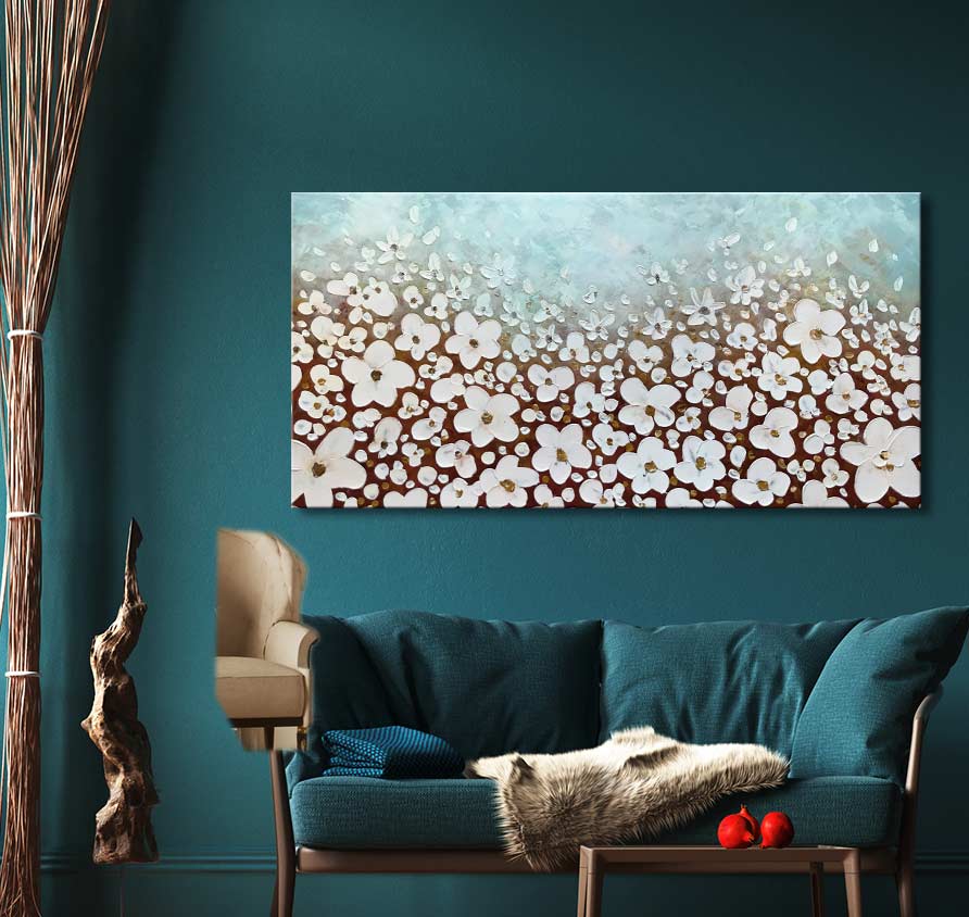 Lentekriebels – Dikke olieverf op canvas: abstracte witte bloemen op bruine en pastelblauwe achtergrond, boven teal sofa. Perfect voor natuurkunstliefhebbers.