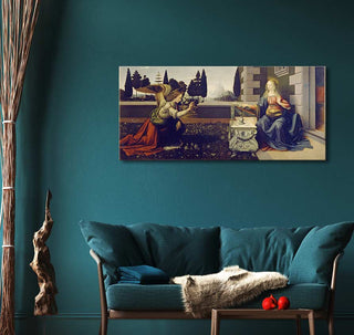 Hand-painted Leonardo da Vinci's Annunciation canvas, depicting angel Gabriel and Mary, adorns a teal-walled living room, highlighting classical art's elegance.