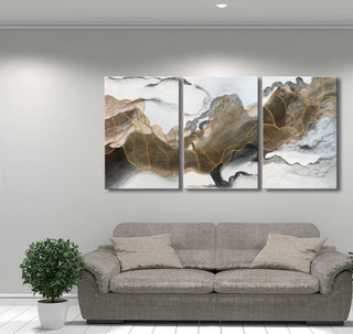 3-Luik Goudweb - Acrylverf op canvas: Drie-panelen schilderij met gouden lijnen op marmeren achtergrond, boven een grijze bank. Perfect voor moderne interieurs.