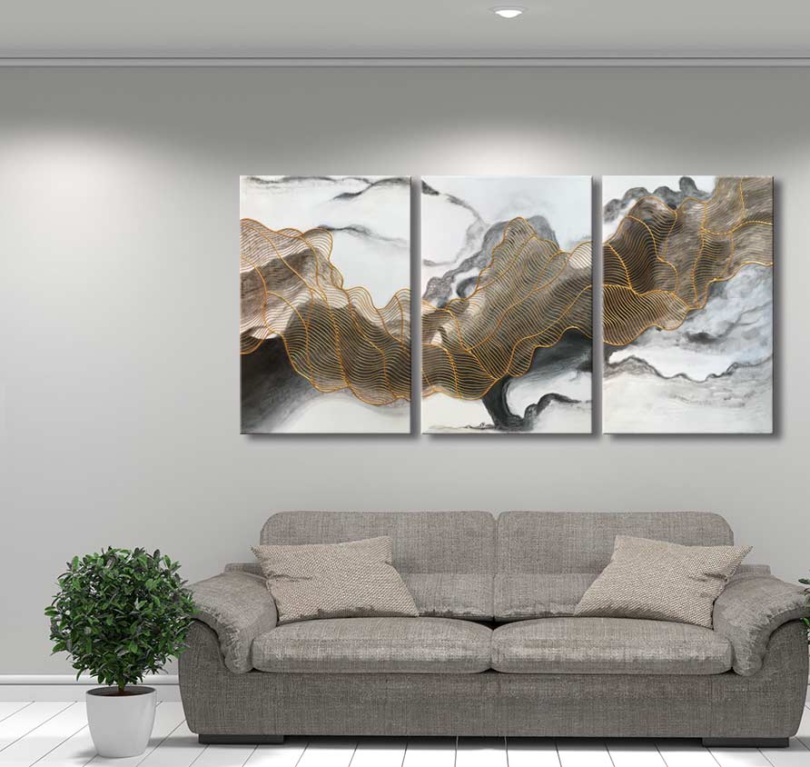 3-Luik Goudweb - Acrylverf op canvas: Drie-panelen schilderij met gouden lijnen op marmeren achtergrond, boven een grijze bank. Perfect voor moderne interieurs.
