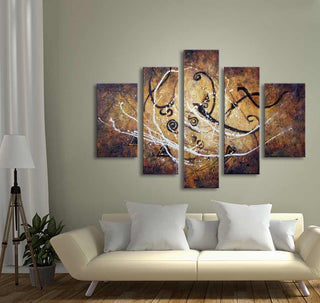 Handgeschilderd 5-Luik Tribal Ideas: abstract schilderij met aardetinten en tribale vormen, hangt boven een crèmekleurige bank in een moderne, gezellige woonkamer.